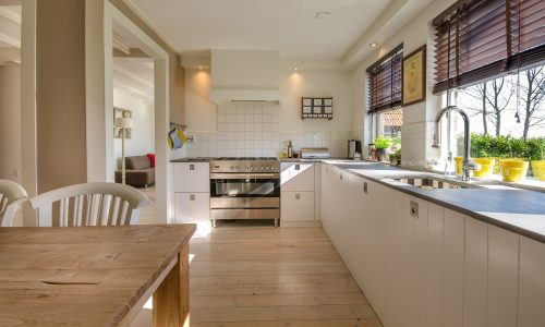 A kitchen with wooden floors and white cabinets.